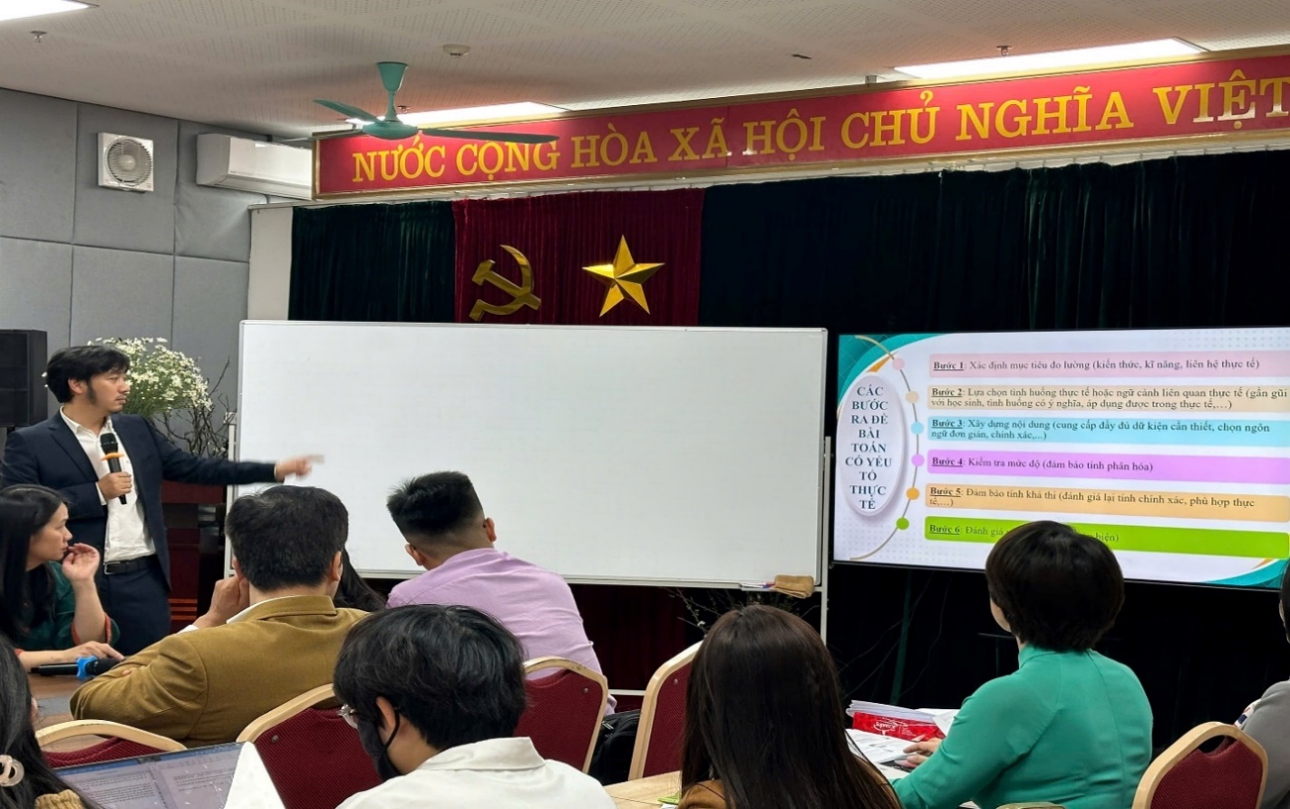 A group of people sitting in chairs in front of a white boardDescription automatically generated