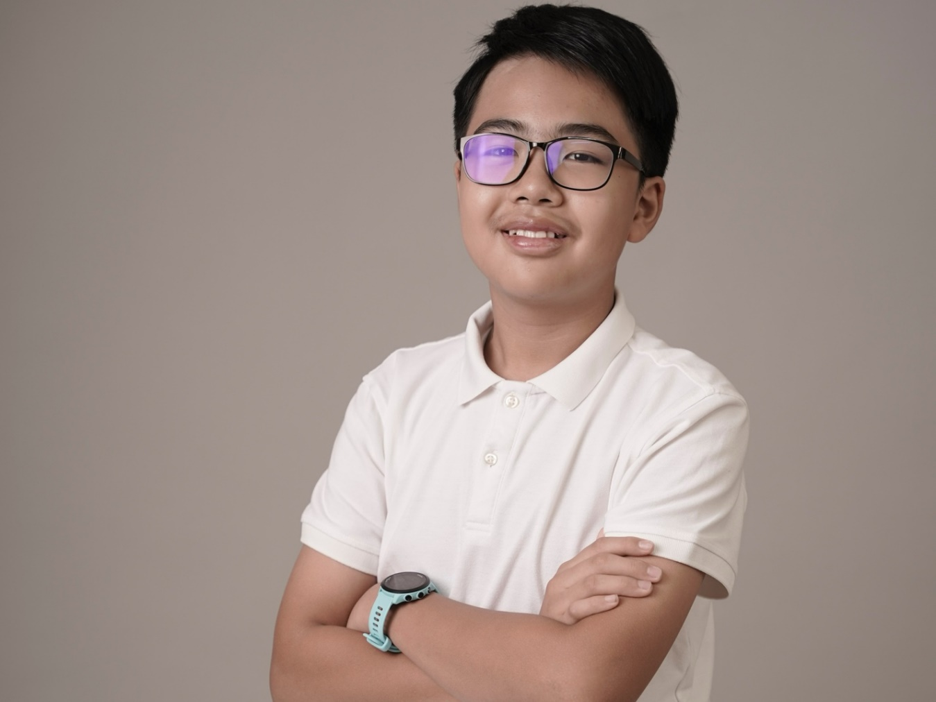 A young person wearing glasses and a white shirtDescription automatically generated