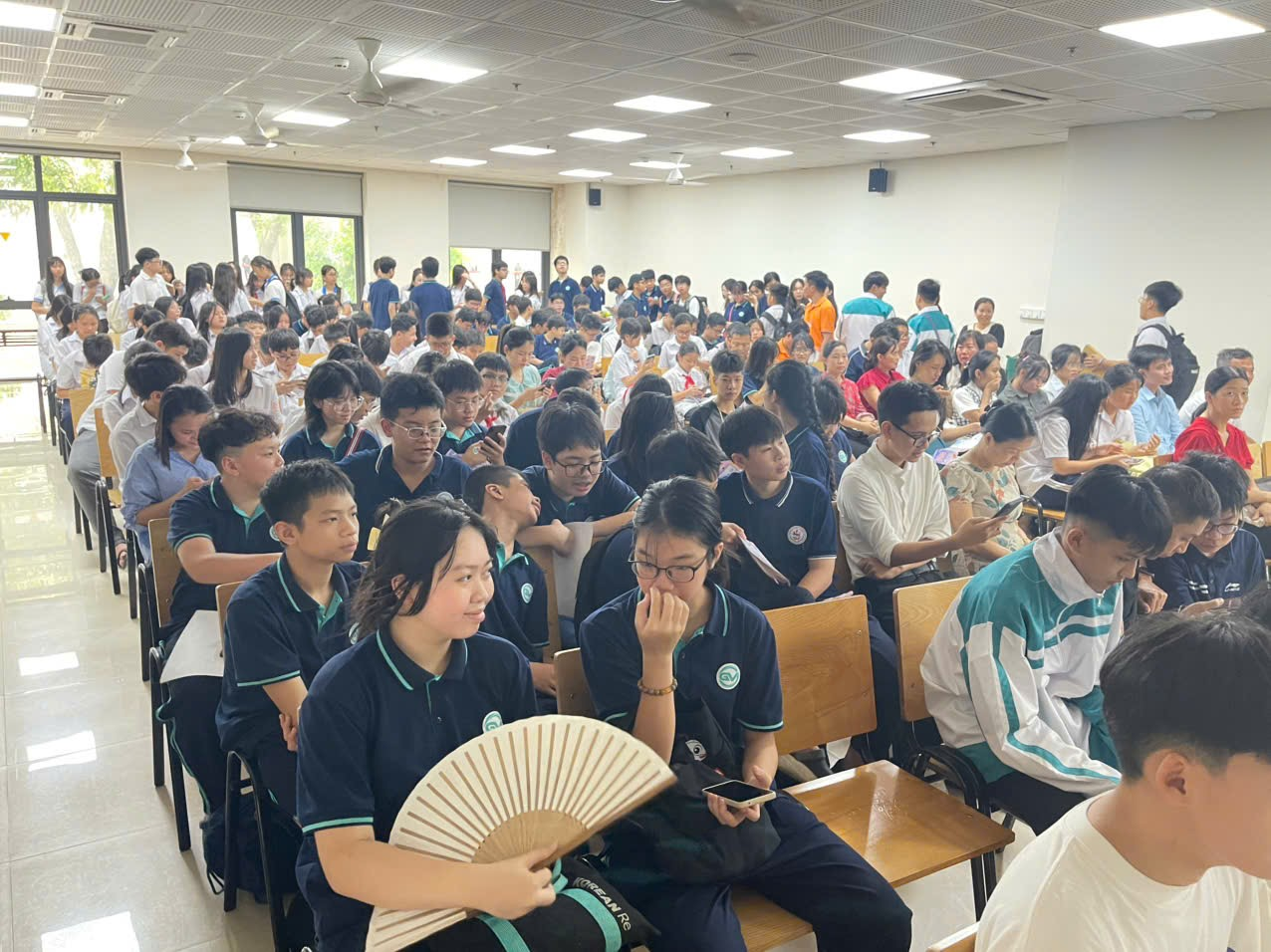 A group of people sitting in a roomAI-generated content may be incorrect.