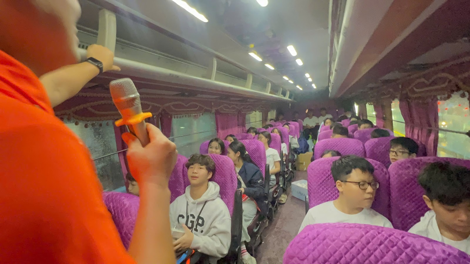 A person holding a microphone in a room of a trainAI-generated content may be incorrect.