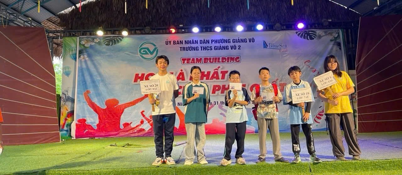 A group of people standing on a stage holding signsAI-generated content may be incorrect.