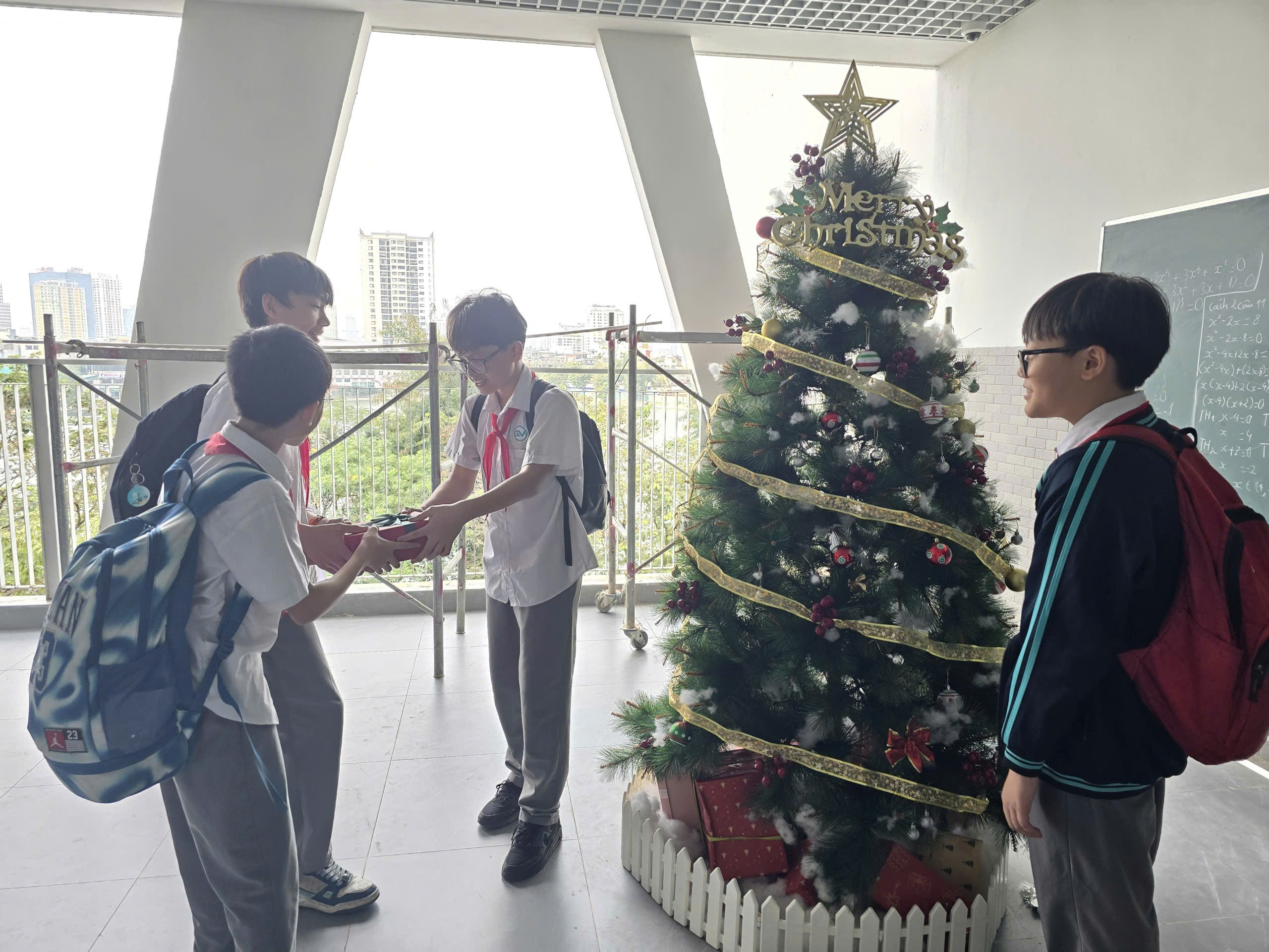 A group of people standing around a christmas treeDescription automatically generated