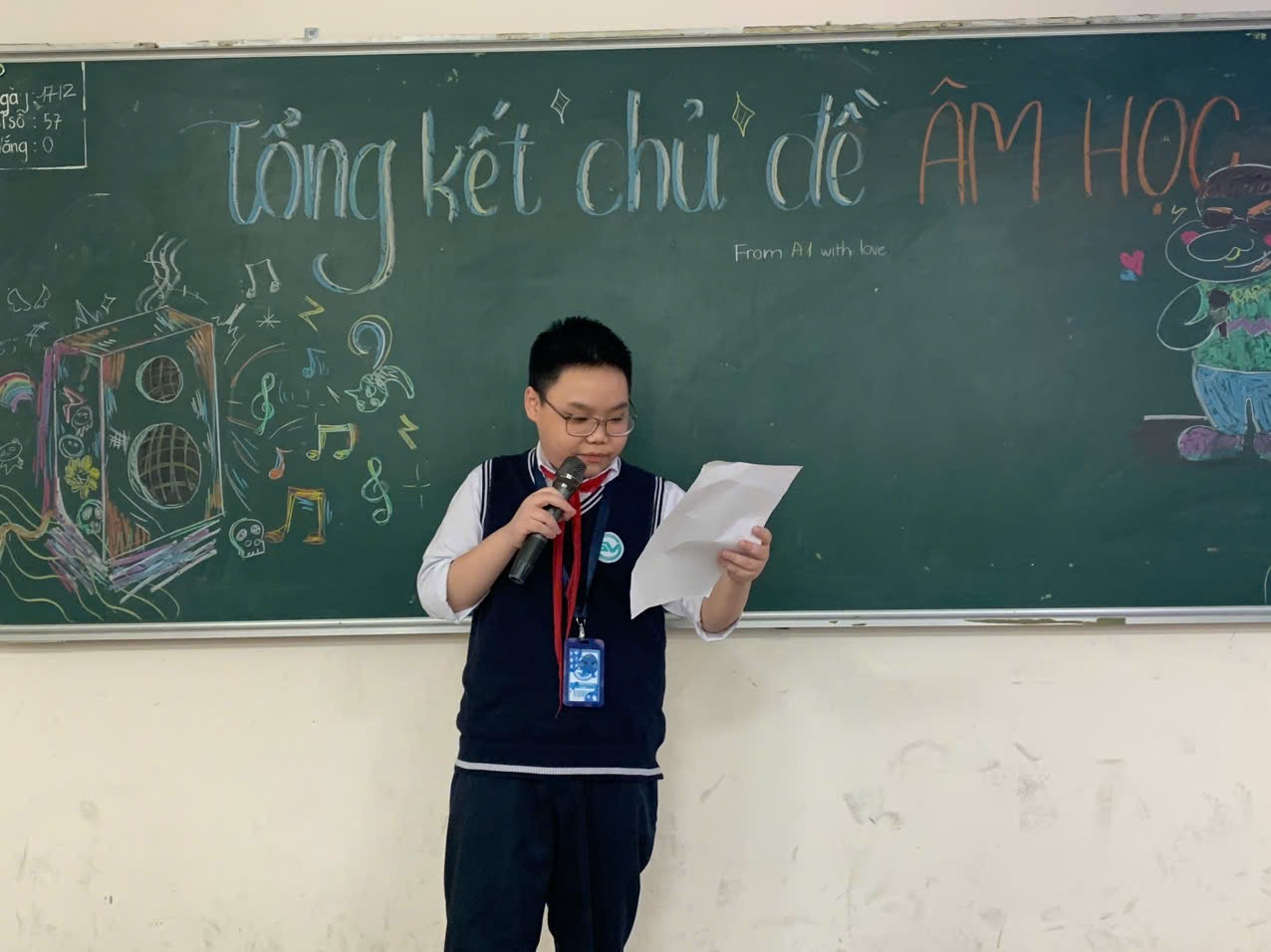 A child standing in front of a chalkboard holding a microphoneAI-generated content may be incorrect.