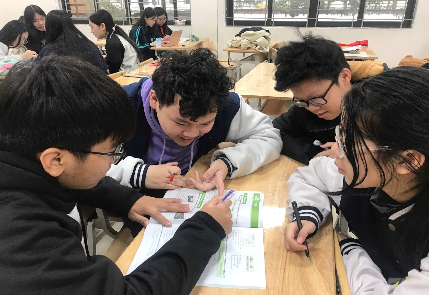 A group of people sitting at a tableAI-generated content may be incorrect.