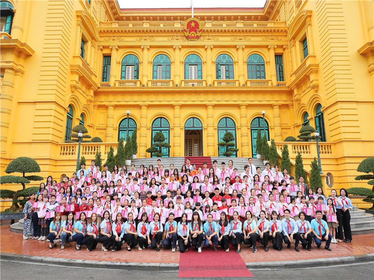 A group of people posing for a photo in front of a yellow buildingAI-generated content may be incorrect.