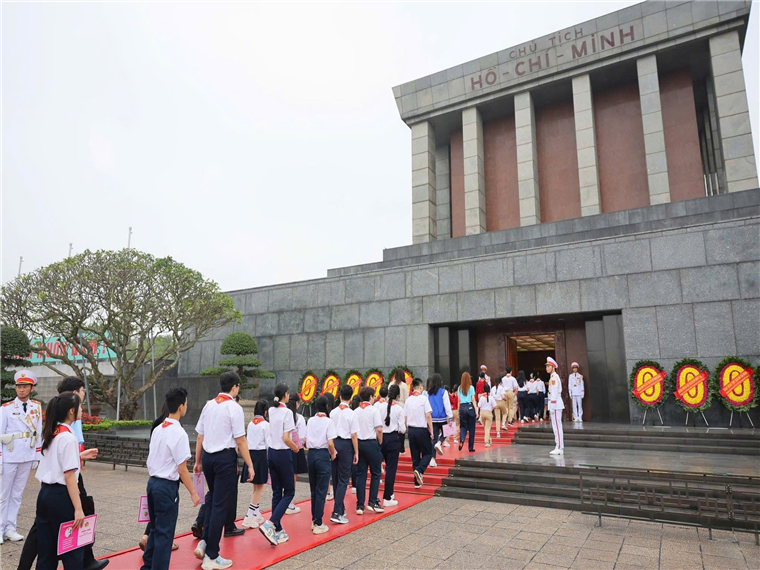 A group of people walking up to Ho Chi Minh MausoleumAI-generated content may be incorrect.