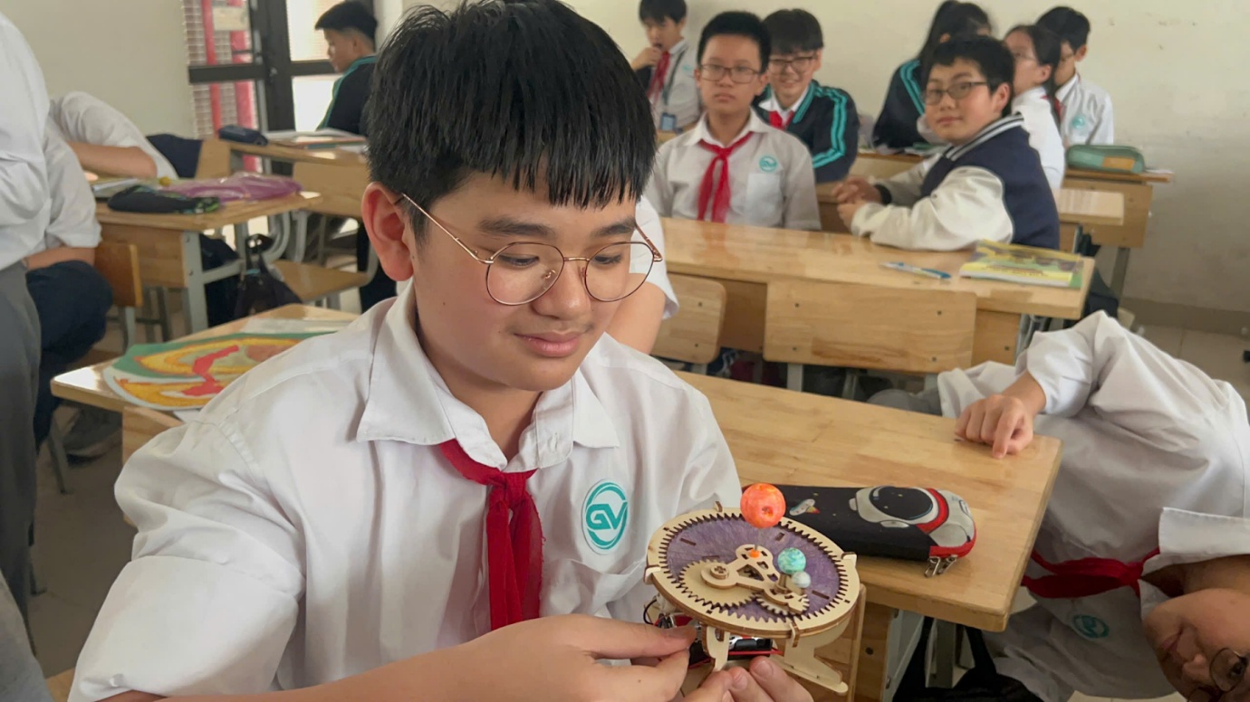 A child in a uniform looking at a toyAI-generated content may be incorrect.