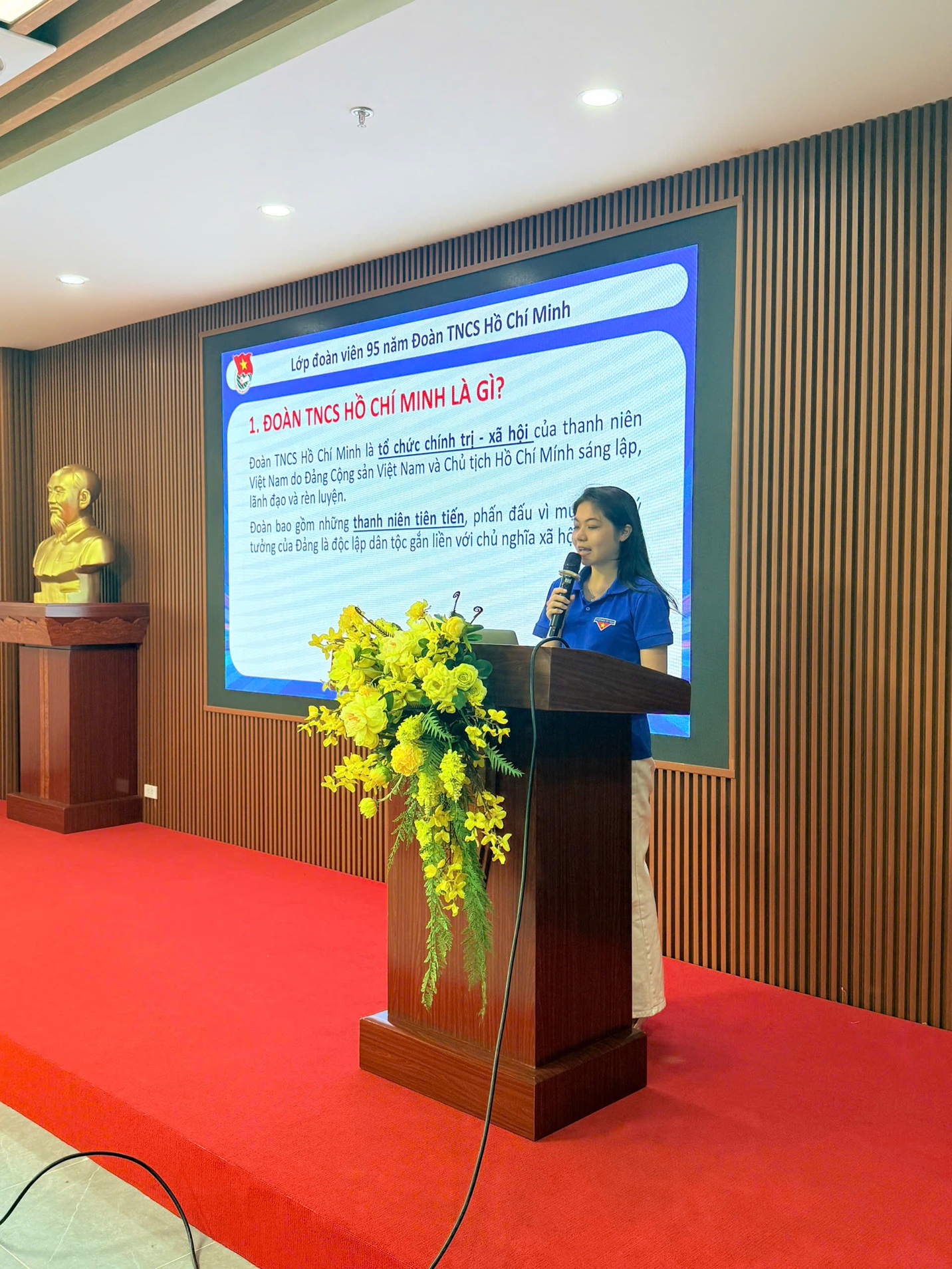 A person standing at a podium with a microphoneDescription automatically generated